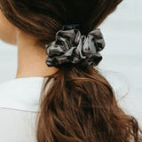 Stor mörkgrå sidensnodd scrunchie i långt brunt hår