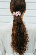 Ladda upp bild till gallerivisning, Stor rosa sidensnodd i scrunchie modell i långt brunt lockigt hår

